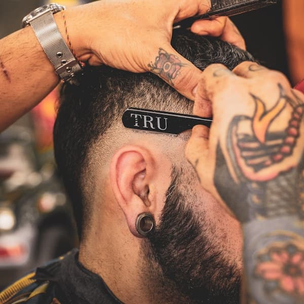 Barber performing a precise skin fade with clippers