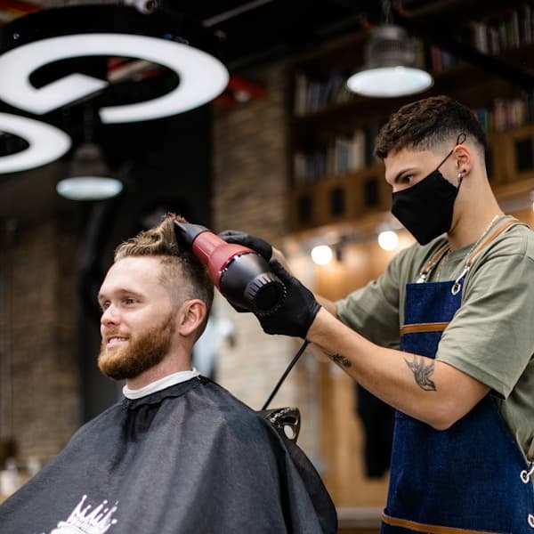Barber styling hair with pomade for a textured finish